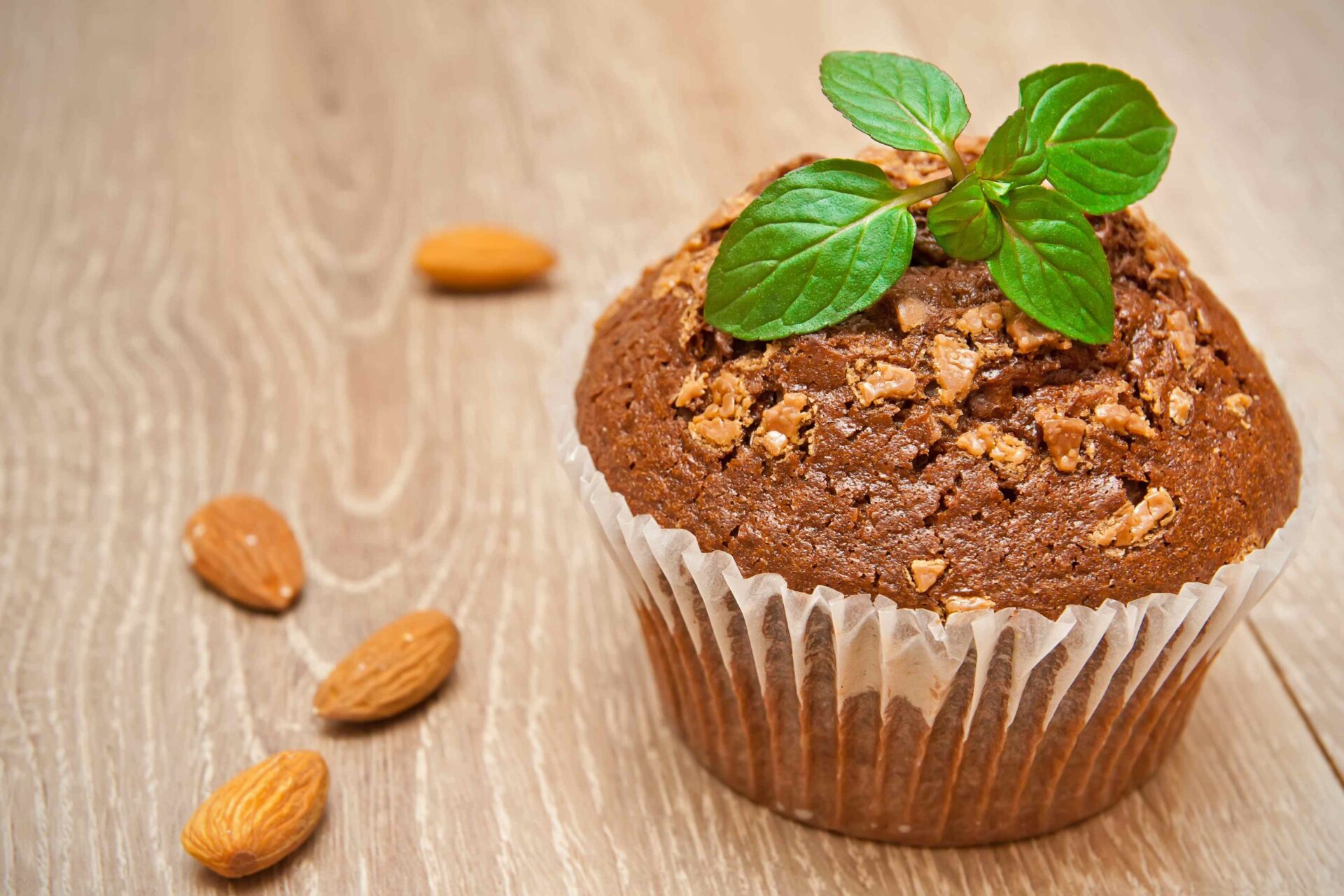 A Muffin Topped with Diced Almonds and Leafy Garnish - Bakery Toppings