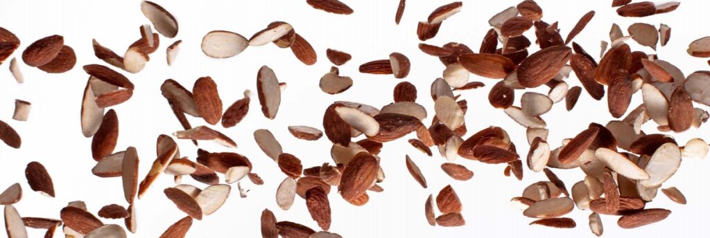 Falling natural almond halves with white background