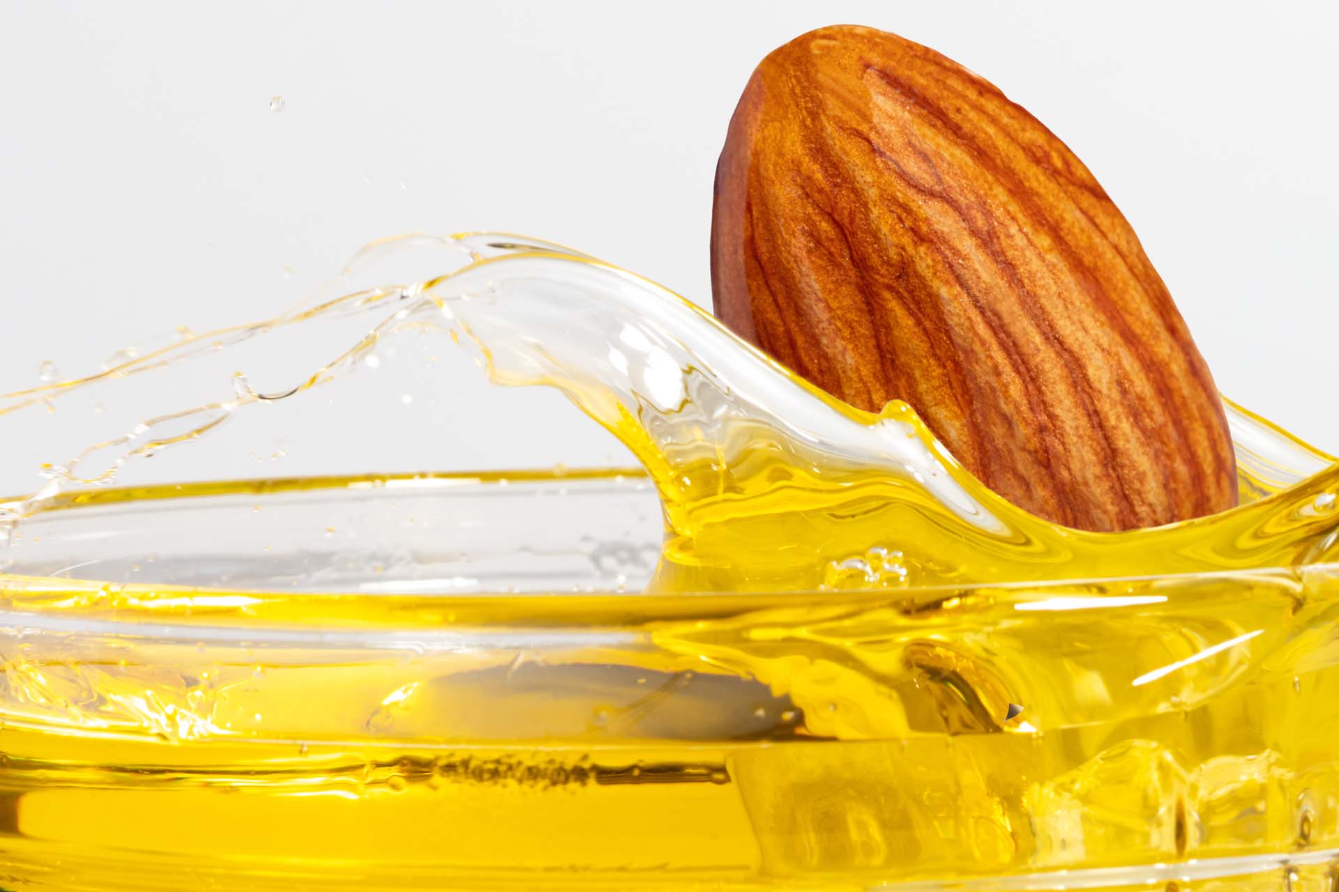 A Whole Almond splashing into Treehouse Almond Oil