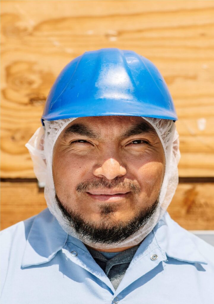 Treehouse Almonds team member in blue hard safety helmet & hair net