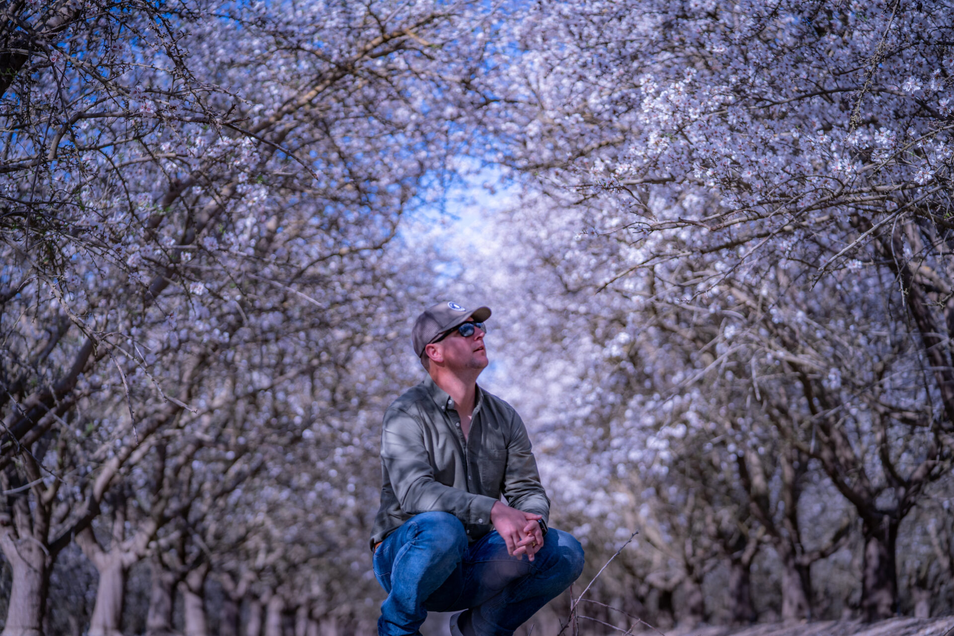 Treehouse Almonds Team Member standing in Almond Orchard - Organic Almond Growing