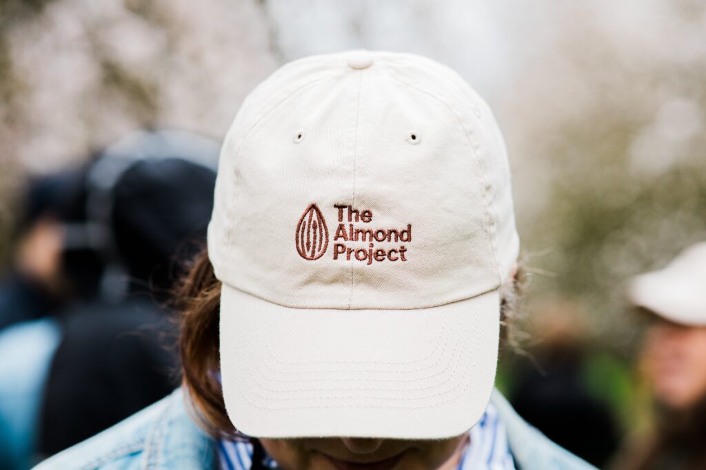 Treehouse Almonds worker wearing a baseball cap that says the Almond Project